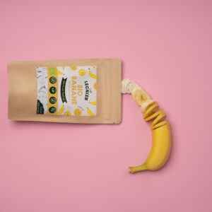 gefriergetrocknete Banane und frische Banane vor rosa Hintergrund