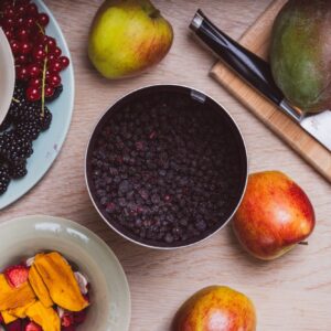 Aronia Beeren neben anderen Früchten