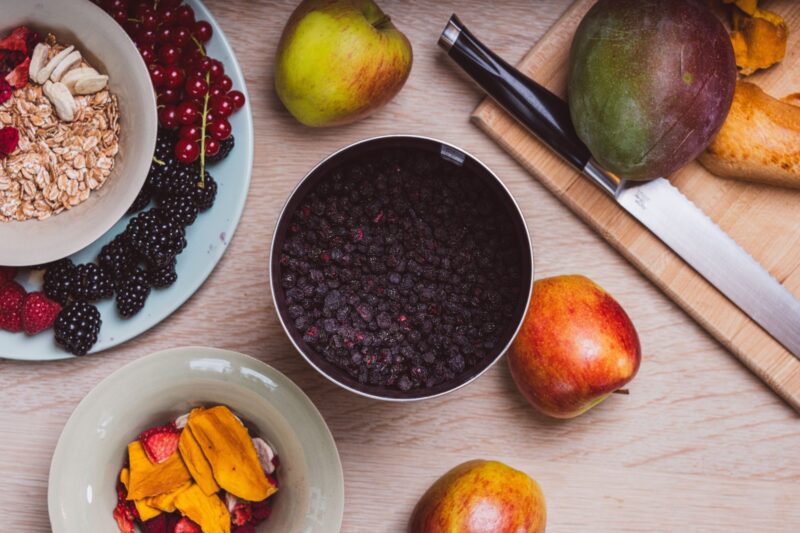 Aronia Beeren neben anderen Früchten
