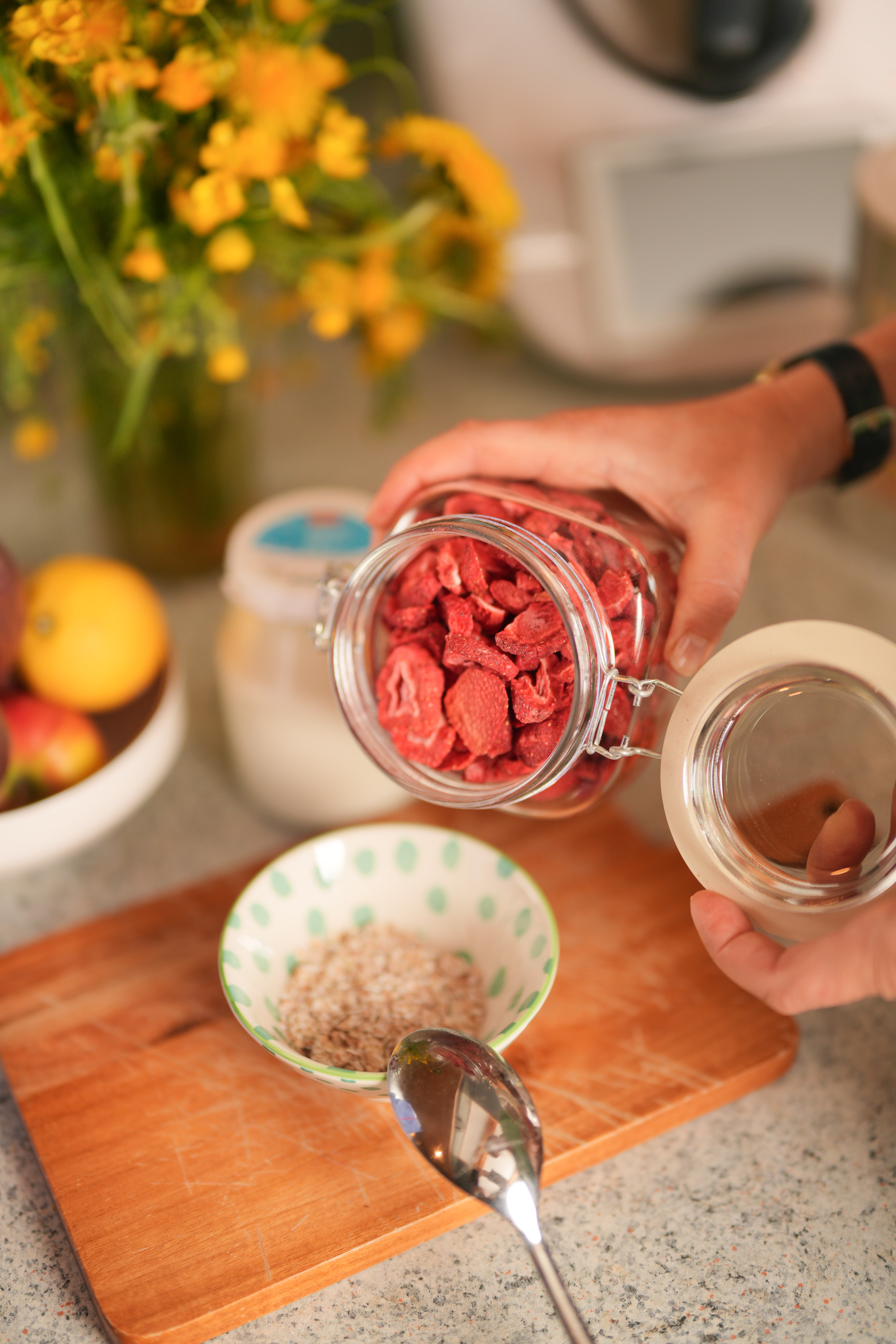 Gefriergetrocknete Erdbeeren werden ins Müsli gegeben